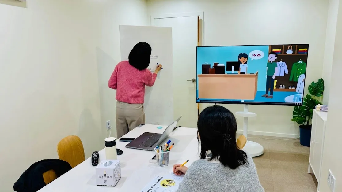 분당 미금역 성인 영어회화 학원 이음영어 분당점의 대면 수업 — 강사가 화이트보드와 학습 영상으로 수업을 진행하는 모습
